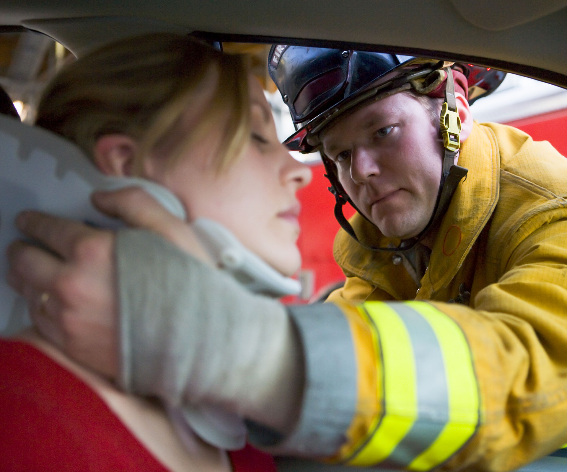 Firefighter supporting injured woman after car accident