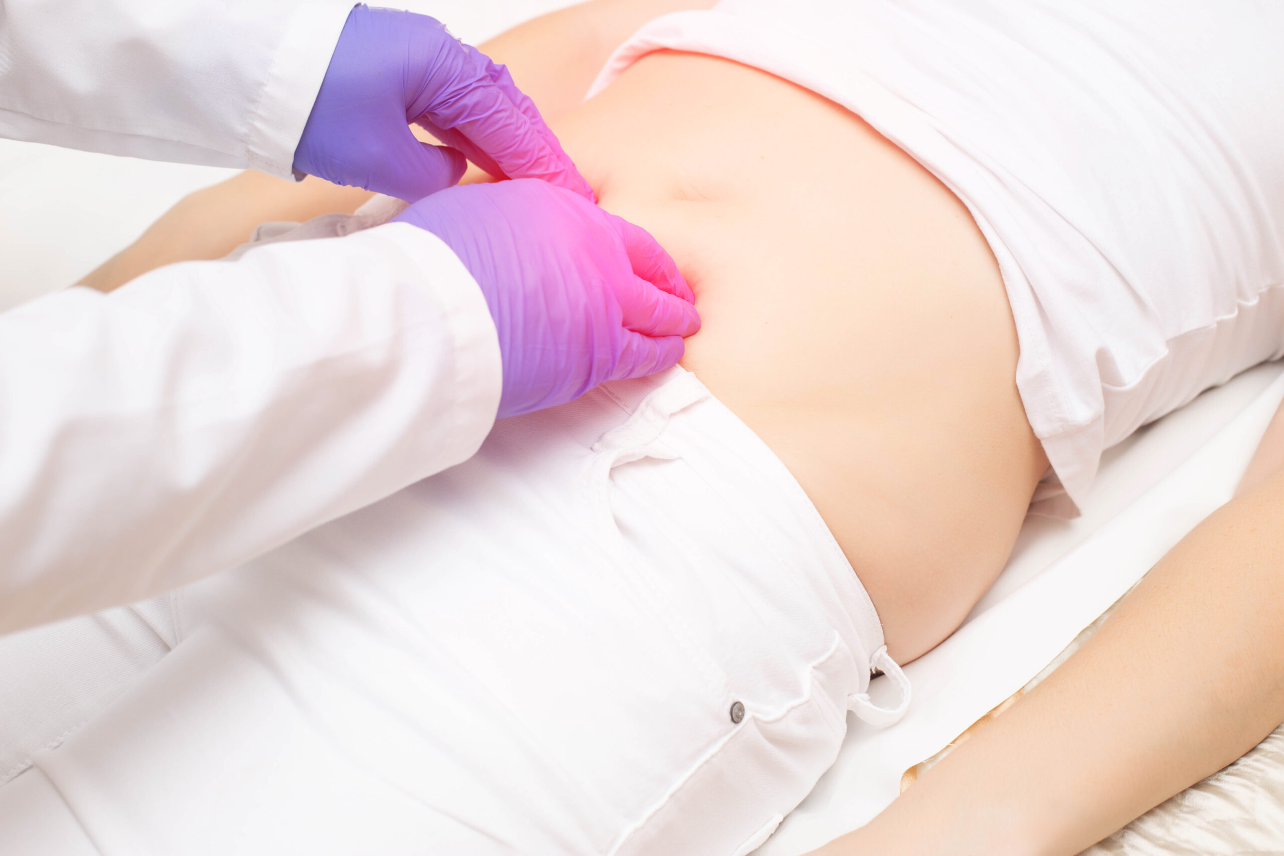 Physiotherapist providing gentle manual pelvic therapy to the lower abdomen
